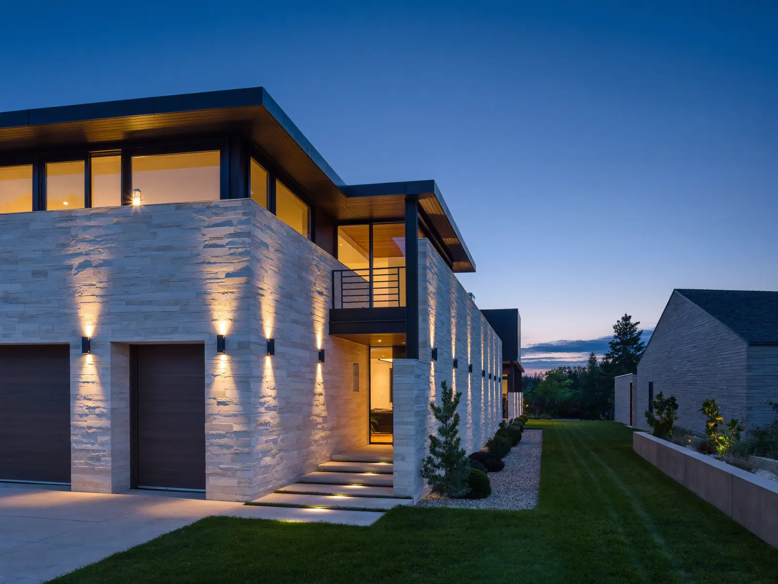Home exterior at dusk with soffit and landscape lighting