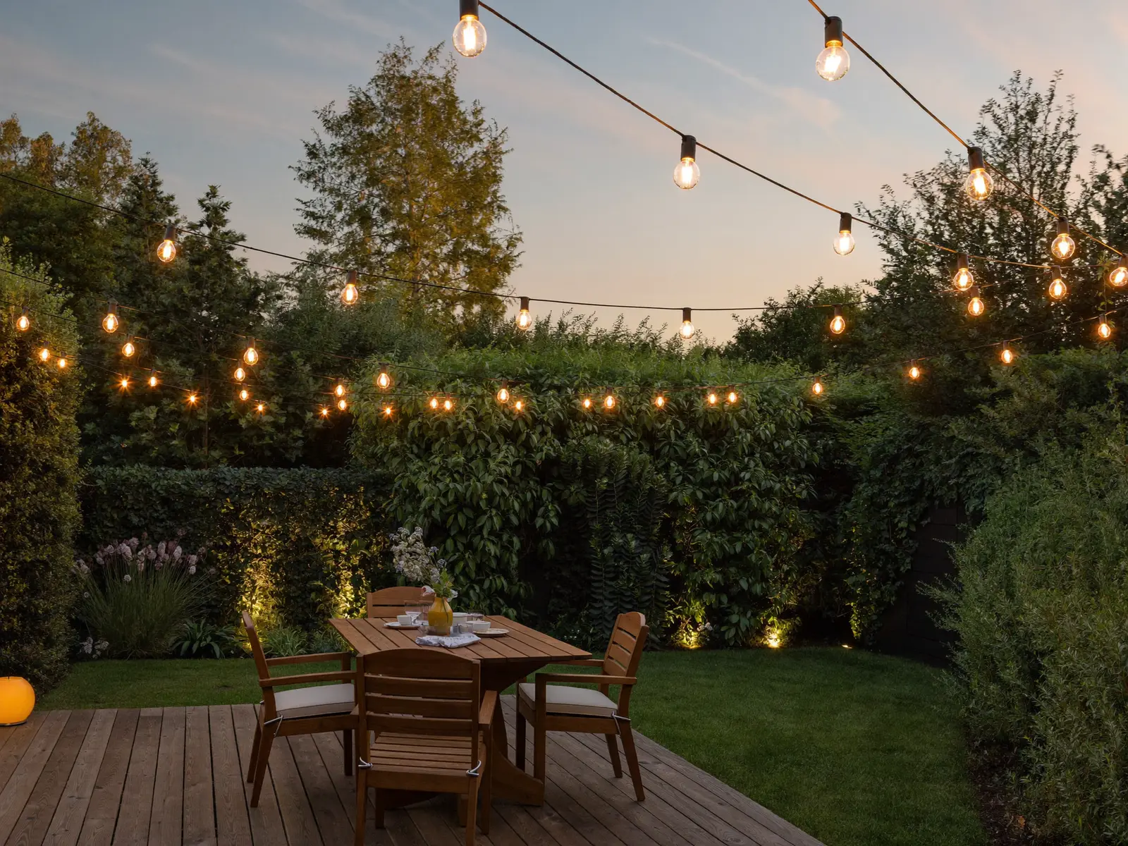 Backyard patio with bistro string lighting at dusk
